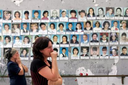 Dos mujeres lloran ante un muro con las fotografías de las víctimas de la masacre en la escuela de Beslán.