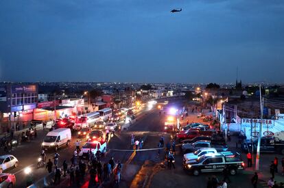 Vista aérea que muestra a miembros de la Fiscalía General del Estado y de la Policía Municipal custodiando el área donde grupos criminales incendiaron un autobús que bloqueaba una carretera en Zapopan, Estado de Jalisco.