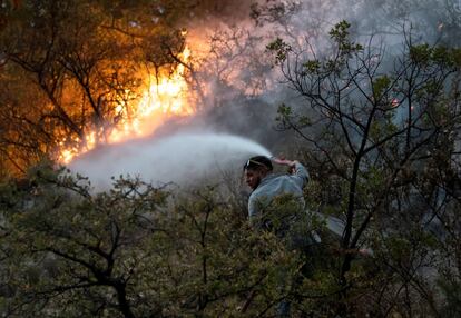 Un brigadista se abre paso entre las llamas en la sierra de Arteaga.