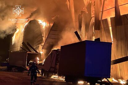 A handout photo made available by the State Emergency Service shows Ukrainian rescuers putting out a fire of industrial storage