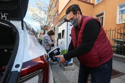 Un usuario recarga su coche eléctrico en un punto situado en la calle en el centro de Madrid.