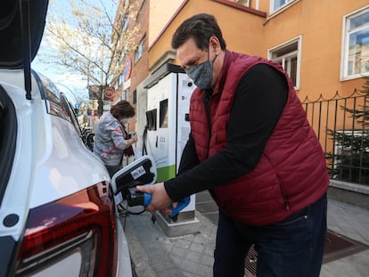Unos usuarios intentando recargar su vehículo en un punto de recarga de coches eléctricos  en la Ronda de Valencia (Madrid).