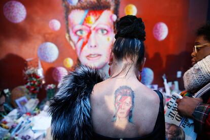 Una mujer con el tatuaje de Ziggy Stardust visita el mural de David Bowie en Brixton (Reino Unido), la legendaria estrella del rock, icono estético y artístico de la segunda mitad del siglo XX, fallecía a los 69 años, víctima del cáncer, el 11 de enero de 2016.