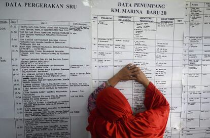 Una mujer indonesia llora mientras comprueba la lista de pasajeros en un centro de crisis para familiares de los 122 pasajeros del transbordador que naufrag este fin de semana, en Siwa (Indonesia).