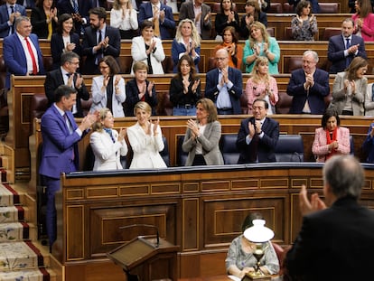 Miembros del Gobierno de coalición y la bancada socialista aplauden en el Congreso de los Diputados.