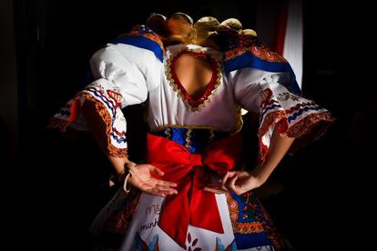 Una mujer ultima los detalles de su vestido tradicional.