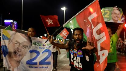 Supporters of Brazil's President and candidate for re-election Jair Bolsonaro and supporters of Brazil's former President Luiz Inacio Lula da Silva campaign together on a street during an election campaign in Brasilia.