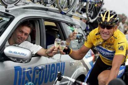 Bruyneel y Armstrong brindan por el séptimo triunfo poco después de la salida de la última etapa, ayer.