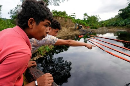 Vecinos observan las labores de limpieza del río en Viche, Ecuador.