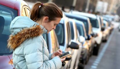 Una mujer paga los parquímetros en la capital.