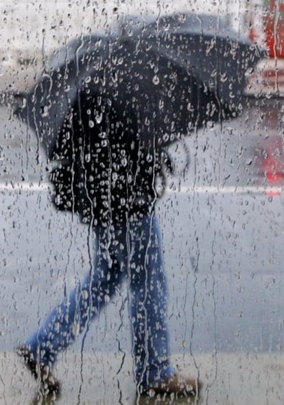 Un hombre camina bajo la lluvia en San Sebastián, donde se ha producido un brusco descenso de las temperaturas.