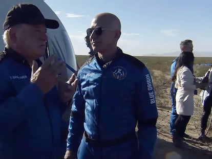 El actor William Shatner, a la izquierda, habla con Jeff Bezos al bajarse de la nave espacial cerca de Van Horn, Texas