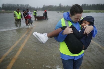 Voluntarios del Equipo Civil de Respuesta a Crisis ayudan a rescatar a tres niños de un hogar inundado en James City.