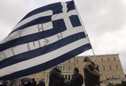 Un manifestante sostiene una bandera de Grecia frente al Parlamento griego en Atenas 