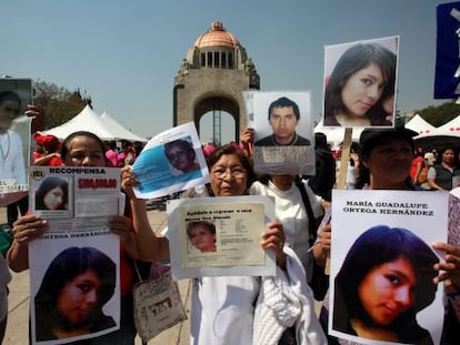 Mujeres muestran fotos de desaparecidos en M&eacute;xico.
