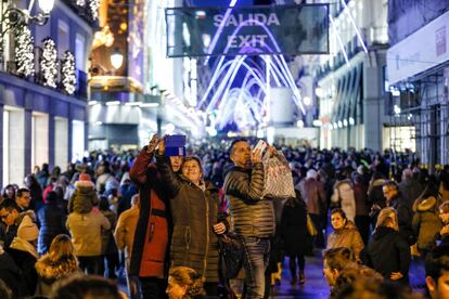 Un grupo de personas se fotografía en la calle de Preciados de Madrid.