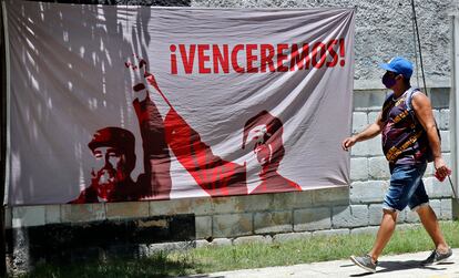 Un hombre camina junto a una tela adornada con una imagen del líder de la revolución cubana Fidel Castro en La Habana (Cuba).