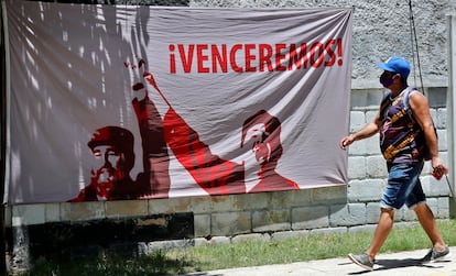 Un hombre camina junto a una tela adornada con una imagen del líder de la revolución cubana Fidel Castro en La Habana (Cuba).