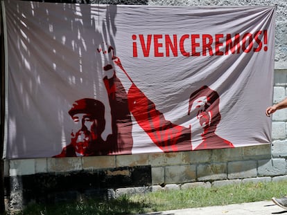 Un hombre camina junto a una tela adornada con una imagen del líder de la revolución cubana Fidel Castro en La Habana (Cuba).