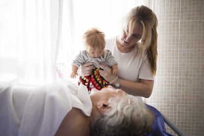 "Os bonecos nos ajudam a incentivá-los a participar de certas atividades, mas nunca como chantagem, mas como estímulo", explica Ana Sanz, terapeuta ocupacional. Na imagem, uma trabalhadora do centro mostra uma boneca a uma das residentes, que está deitada no banheiro geriátrico do centro.