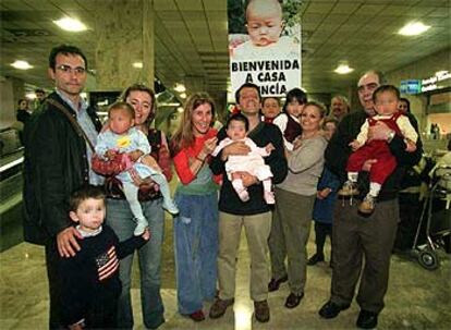 Un grupo de padres posa con sus hijas chinas en el aeropuerto madrileño de Barajas.