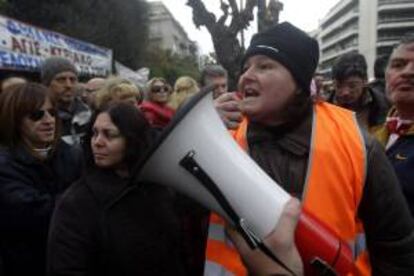 Una vigilante de colegio que ha sido suspendida con una reducción de sueldo antes de ser despedida corea consignas a las puertas del Ministerio de Reforma Administrativa en Atenas (Grecia) hoy.