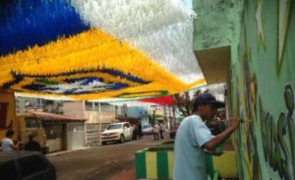 Moradores enfeitam rua para a Copa.