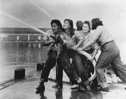 Varias mujeres tratan de sofocar un incendio provocado durante el bombardeo japonés a la base naval de Pearl Harbour.