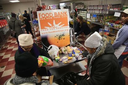 Ciudadanos de Harlem escogen productos en un banco de alimentos.