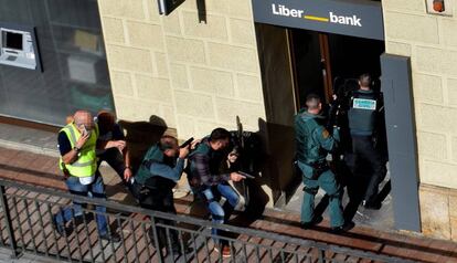 La Guardia Civil entra en la surcursal de Liberbank de Cangas de On&iacute;s para detener al atracador, que se hab&iacute;a disparado.