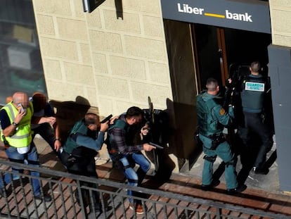 La Guardia Civil entra en la surcursal de Liberbank de Cangas de On&iacute;s para detener al atracador, que se hab&iacute;a disparado.