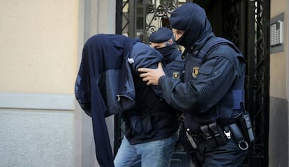 Two Mossos take off a suspect of Brussels terror attacks in Barcelona.