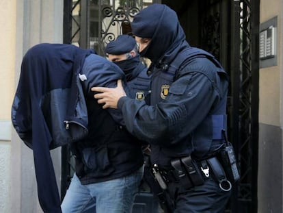 Two Mossos take off a suspect of Brussels terror attacks in Barcelona.