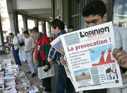 Un ciudadano marroquí lee un periódico oficialista en Rabat, en cuya portada se califica de provocación la visita de los Reyes a Ceuta y Melilla.
