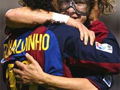 Puyol abraza a Ronaldinho tras marcar el brasileño uno de sus goles.