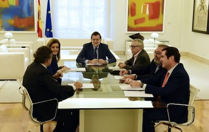 El presidente del Gobierno, Mariano Rajoy, en el centro de la mesa, en una reunión en La Moncloa, con la ministra de Empleo, y los líderes de los agentes sociales