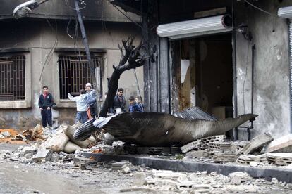 Un grupo de niños juega en las inmediaciones de un comercio destruido.