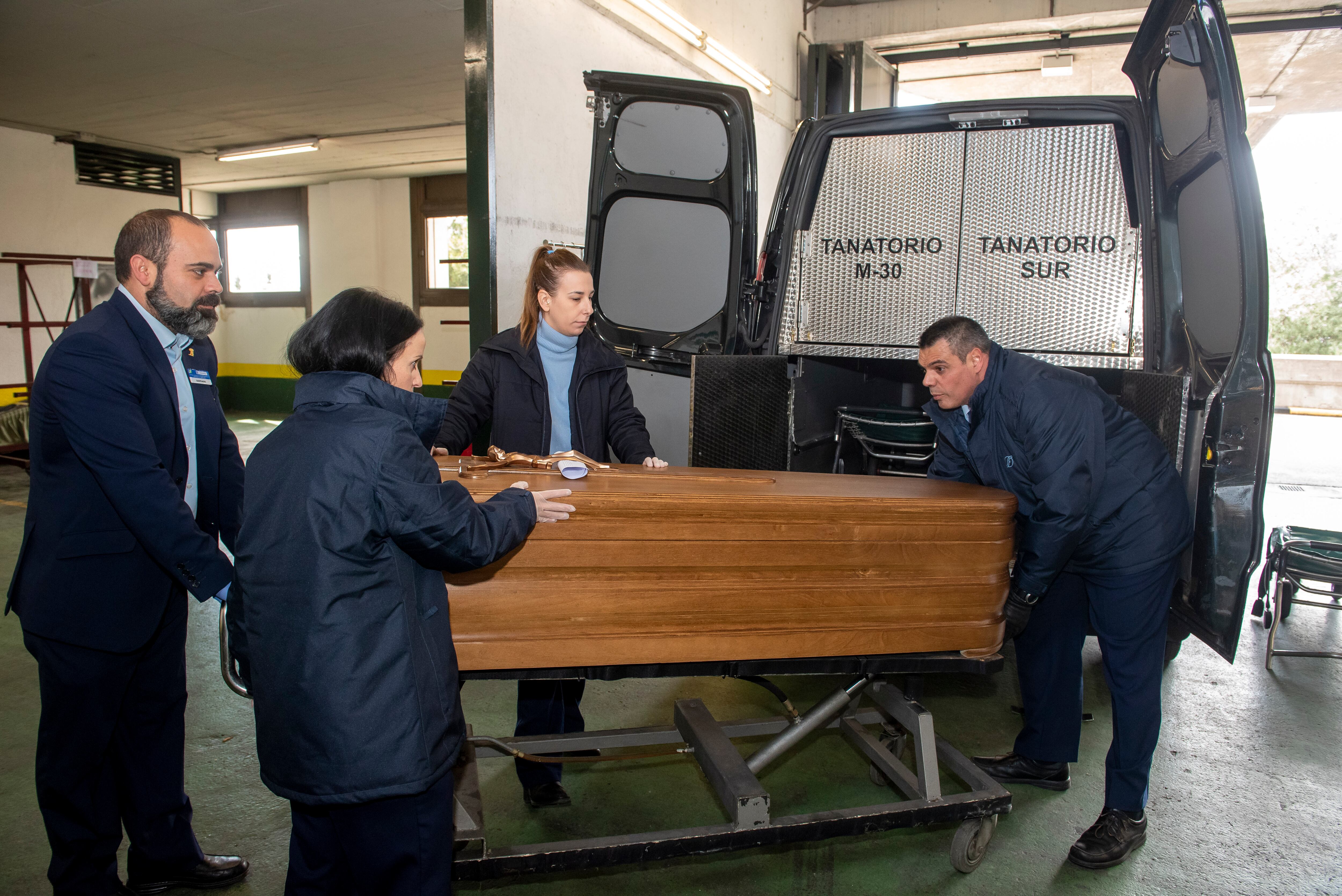 José Luis Pérez Pedrero, a la derecha, saca un féretro de un furgón fúnebre en el tanatorio de la M-30. 