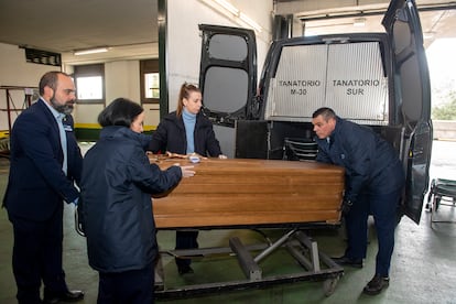 José Luis Pérez Pedrero, a la derecha, saca un féretro de un furgón fúnebre en el tanatorio de la M-30.
