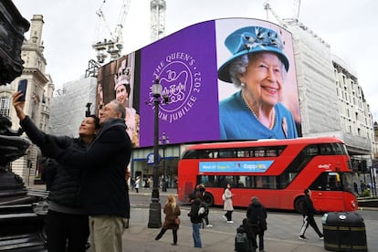 Una pareja haciéndose un 'selfi' delante de las pantallas digitales de Picadilly Circus (Londres), que durante todo el día proyectan imágenes de la monarca.