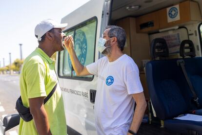 Valentín Márquez, coordinador de Andalucía del Programa de Inclusión de Médicos del Mundo, le hace  la prueba de la hepatitis C a Said Bahari, este mediodía en calle Torneo de Sevilla.