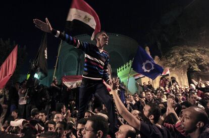 Los manifestantes celebran la ruptura de las últimas barricadas de alambre de púas que custodiaban el palacio presidencial en El Cairo.