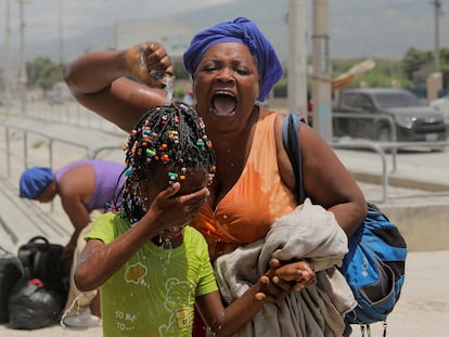 Una mujer auxilia a su hija tras recibir una carga de gas lacrimógeno en Puerto Príncipe (Haití) el 25 de julio 2023.