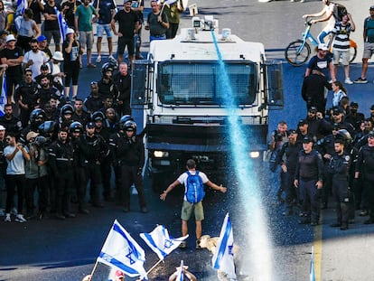 Una persona ante un cañón de agua israelí durante una protesta contra el plan del Gobierno para reformular el sistema judicial en Jerusalén el pasado 24 de julio.