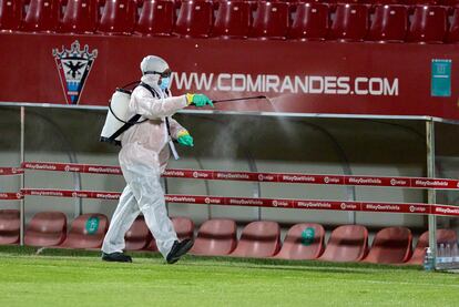 Un operario desinfecta los banquillos del estadio Municipal de Anduva.