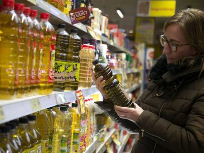 Una mujer mira varias botellas de aceite de oliva en un supermercado, en una imagen de archivo.