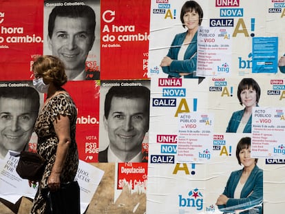 Una mujer pasa ante los carteles electorales de los candidatos del PSdeG, Gonzalo Caballero, y del BNG, Ana Ponton  a la presidencia de la Xunta de Galicia.