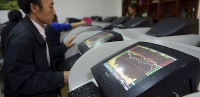 Investors look at computer screens showing stock information at a brokerage house in Qingdao