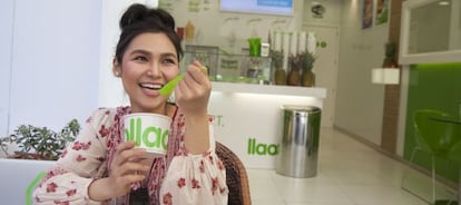 Una mujer toma un yogur helado en una tienda Llaollao en Madrid.