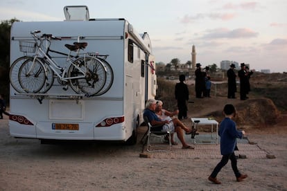 Unos viajeros judíos sentados fuera de su caravana.